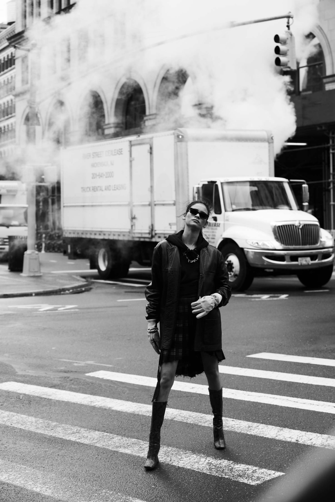 Juana Burga crossing a New York street amid steam — black-and-white photograph by Javier Falcón