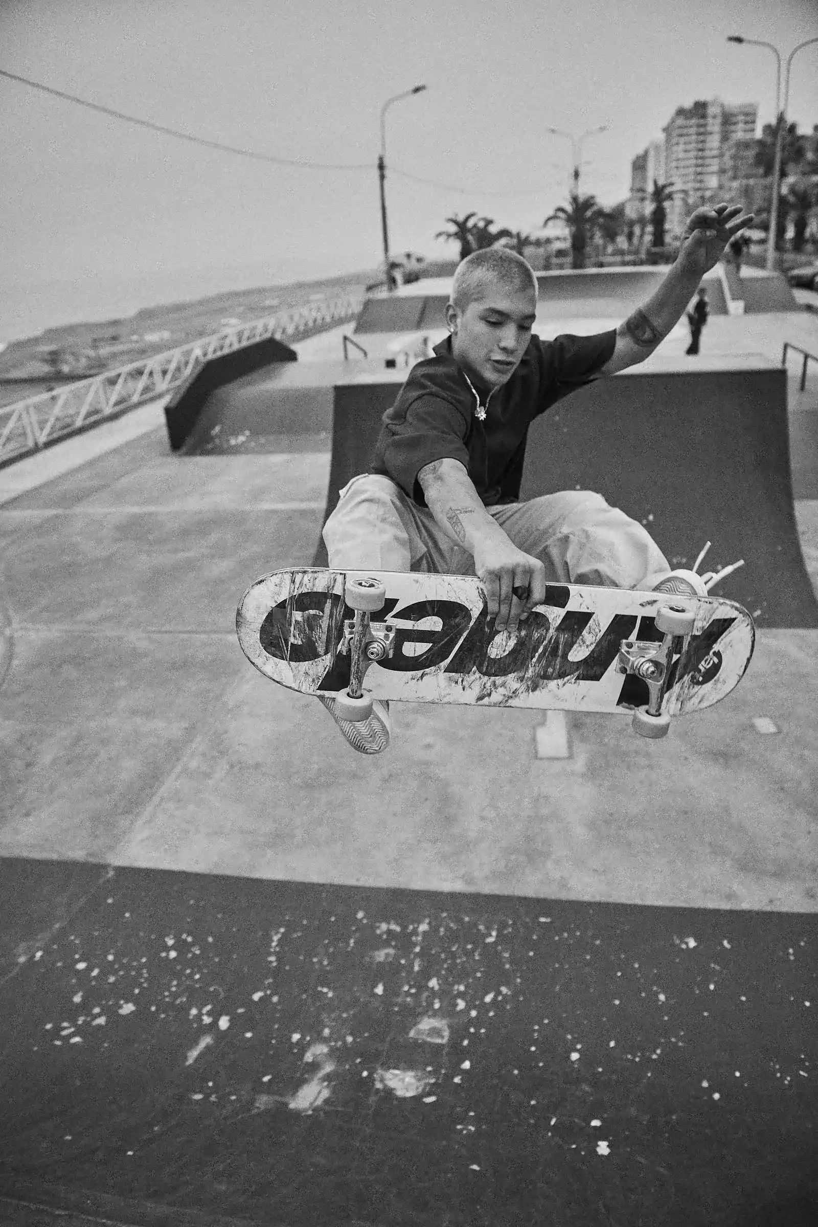 Skater Angelo Caro mid-air at a Lima skatepark, black-and-white photograph by Javier Falcón